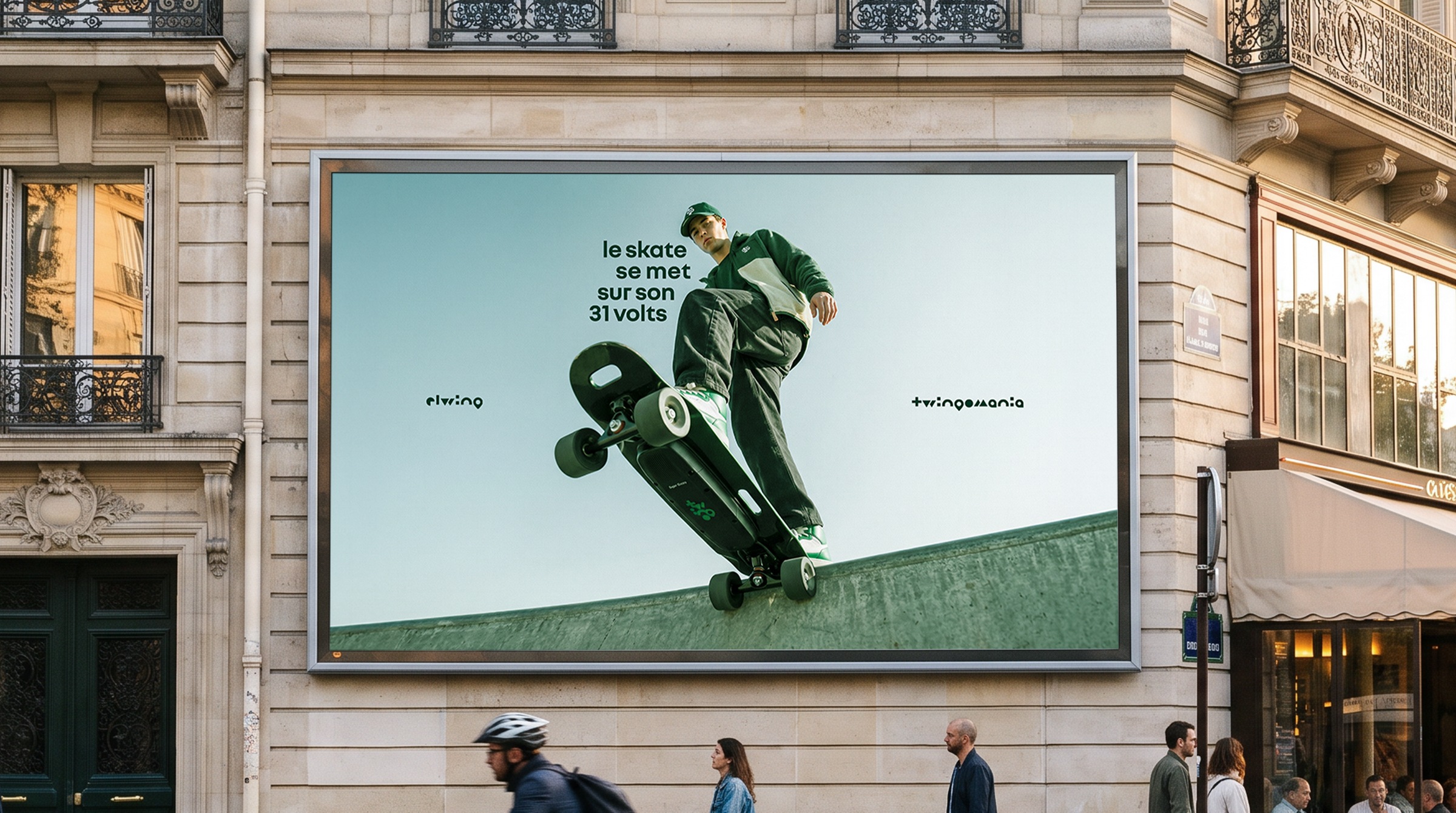 Twingomania Renault : un skateur en tenue verte avec un skateboard électrique, photographié en contre-plongée.